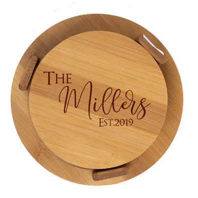 Wooden round cutting board with 'The Millers Est. 2019' engraving on a white background