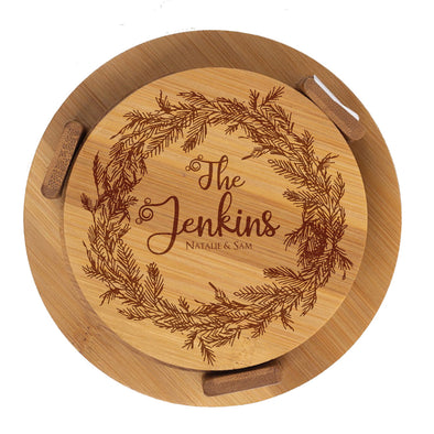Round wooden cutting board with engraved wreath and 'The Jenkins' text on a white background